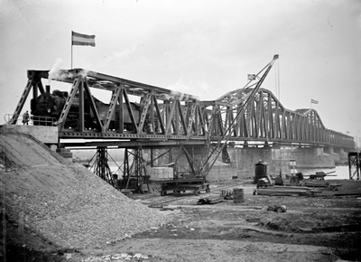 166383 Gezicht op de van oorlogsschade herstelde spoorbrug over de Maas bij Hedel, met enkele Duitse stoomlocomotieven ...